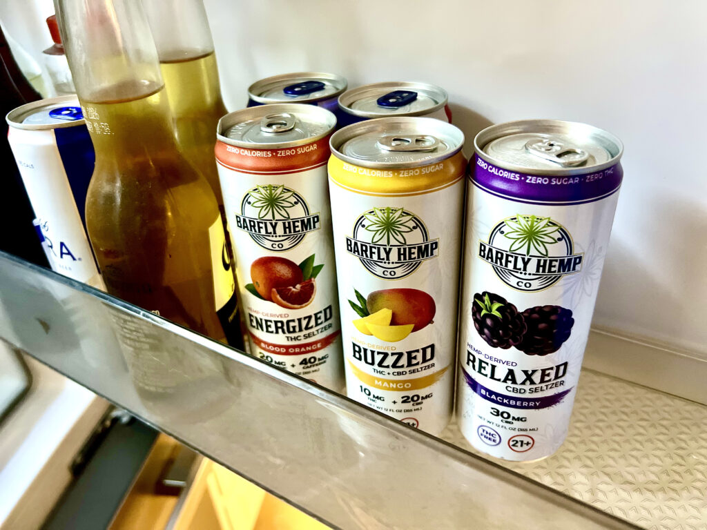 Barfly THC seltzers in the refrigerator next to alcoholic beverages